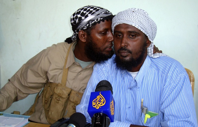 Sheik Muktar Robow Abu Mansur, former spokesman for the al Shabaab hardliners, talks to his successor Sheik Ali Mohamoud Rage as they address journalists in the Somalia capital Mogadishu